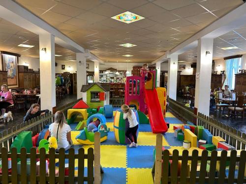 a group of children playing in a play area in a library at Hotel Restaurant Svejk in Bublava