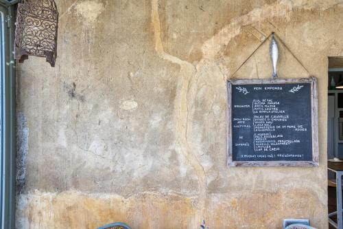 a stone wall with a sign on it at Les Hamaques Hotel in Viladamat