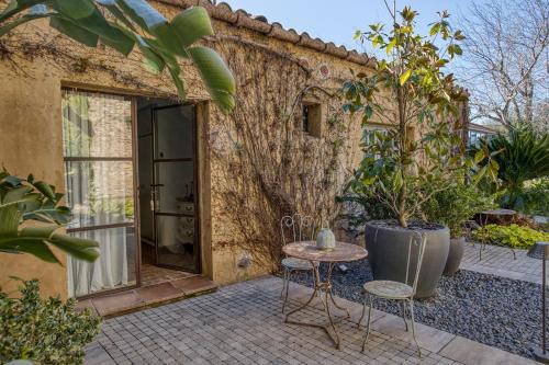 a patio with a table and chairs in front of a building at Les Hamaques Hotel in Viladamat