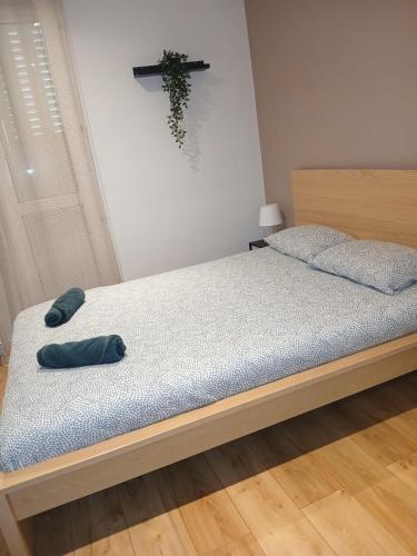 un lit avec deux oreillers dessus dans une chambre dans l'établissement Kalaban - Moderne - Paris, CDG, Disney, Expo Parc, à Gagny