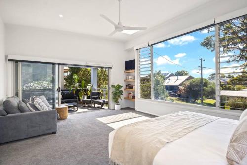 a bedroom with a bed and a large window at Bawley Beach Escape in Bawley Point