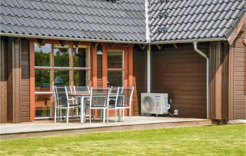 a house with a deck with a table and chairs at Holiday Home Brombærvej Xi in Lem