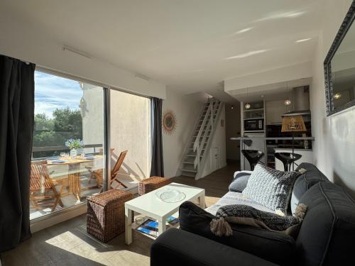 un salon avec un canapé et une table dans l'établissement Le Solarium au bord des flots, à Sète