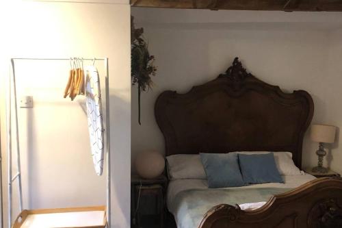 a bedroom with a large bed with blue pillows at Milk Shed - Couples Seaside Retreat Whitstable in Kent