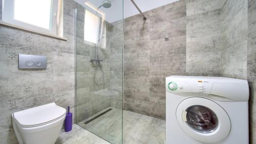 ein Badezimmer mit Toilette und Glasdusche in der Unterkunft Luxury five stars villa with pool, near beach - by TRAVELER tourist agency Krk - ID 2140 in Pinezici