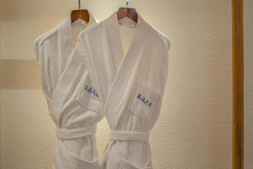 a white robe is hanging on a wall at 夕露古城中心店 XILU INN NANXI - Ancient City Center Branch in Lijiang