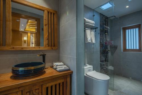 a bathroom with a toilet and a mirror at 夕露古城中心店 XILU INN NANXI - Ancient City Center Branch in Lijiang