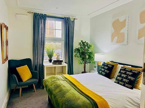 a bedroom with a bed and a chair and a window at Meadows Court - Wyndale Living - Mansion Style Apt in Birmingham