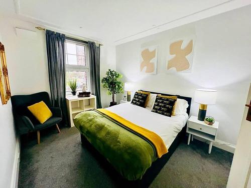 a bedroom with a king sized bed and a chair at Meadows Court - Wyndale Living - Mansion Style Apt in Birmingham