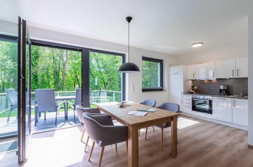a kitchen and dining room with a table and chairs at Gelassenheit - modernes Apartment am Krakower See in Krakow am See