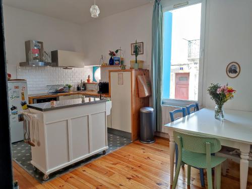 Il comprend une cuisine équipée d'un réfrigérateur et d'une table avec des chaises. dans l'établissement Chez Paul et Valéry, à Sète