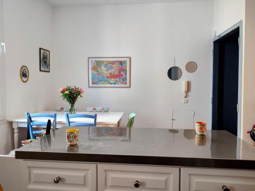 une cuisine avec un comptoir et une table avec des chaises dans l'établissement Chez Paul et Valéry, à Sète