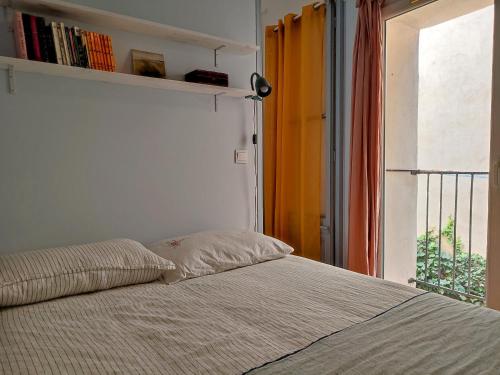 - une chambre avec un lit avec une étagère et une fenêtre dans l'établissement Chez Paul et Valéry, à Sète