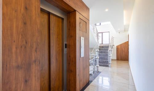 a hallway with wooden doors and stairs in a house at Treebo Anjukul in Dalhousie