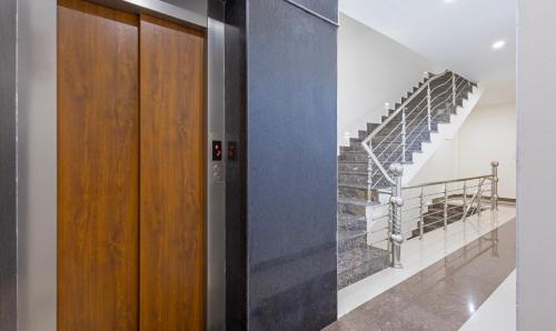a staircase in a house with a wooden door at Treebo Anjukul in Dalhousie