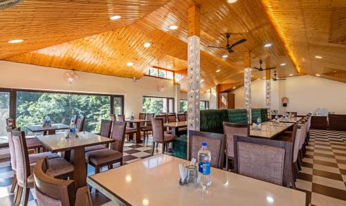 a restaurant with wooden ceilings and tables and chairs at Treebo Anjukul in Dalhousie