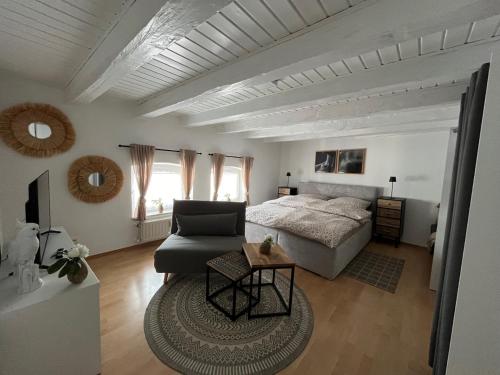 a bedroom with a bed and a couch and a table at Schöne Ferien-Wohnung in Fulda Innenstadt in Fulda