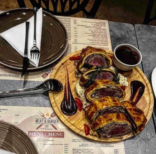 a plate of food with meat on a table at Sunraf Luxe Apartments in Budva