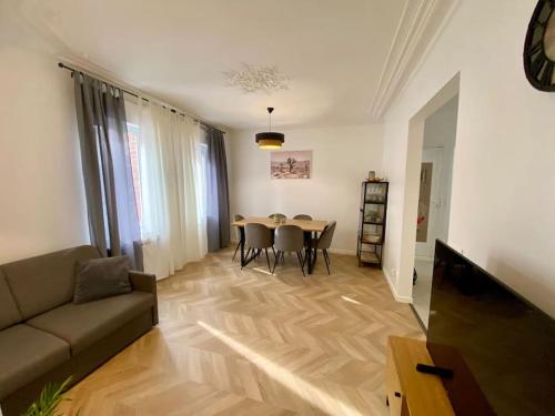 un salon avec un canapé et une table avec des chaises dans l'établissement Duplex Casa Adriana à Fecamp, à Fécamp