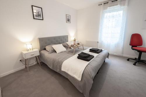 a bedroom with a bed and a red chair at Tout confort à Massy - Parking / TGV et RER B&C in Massy