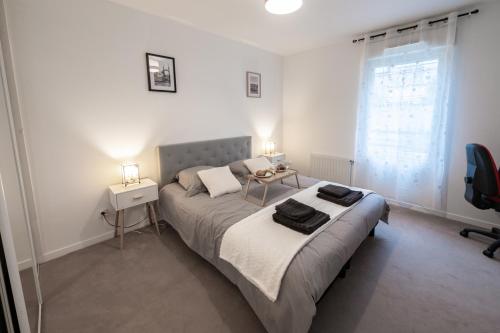 a bedroom with a bed and a table and a window at Tout confort à Massy - Parking / TGV et RER B&C in Massy