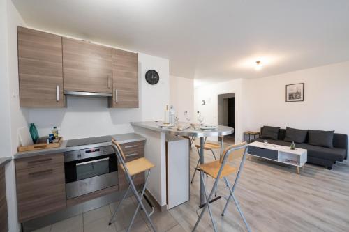 a kitchen and living room with a table and chairs at Tout confort à Massy - Parking / TGV et RER B&C in Massy