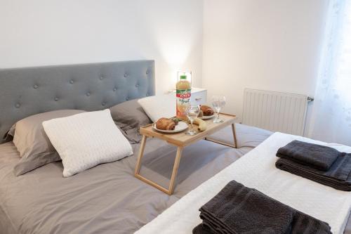 a bed with a table with food and wine glasses at Tout confort à Massy - Parking / TGV et RER B&C in Massy