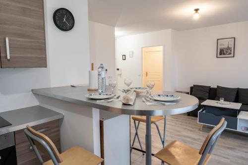 a kitchen and living room with a table and chairs at Tout confort à Massy - Parking / TGV et RER B&C in Massy