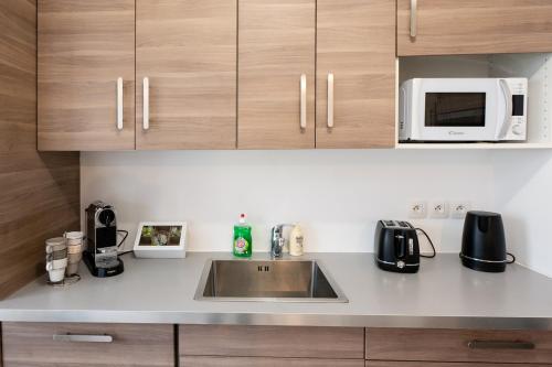 a kitchen with a sink and a microwave at Tout confort à Massy - Parking / TGV et RER B&C in Massy