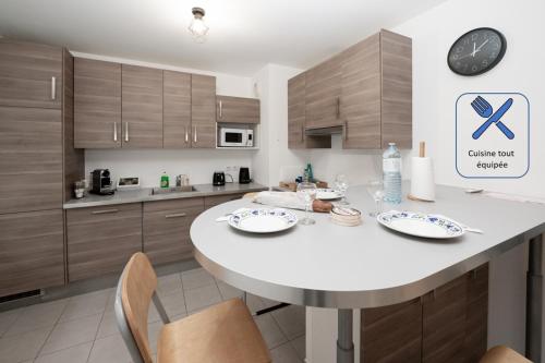 a kitchen with a large white table and chairs at Tout confort à Massy - Parking / TGV et RER B&C in Massy