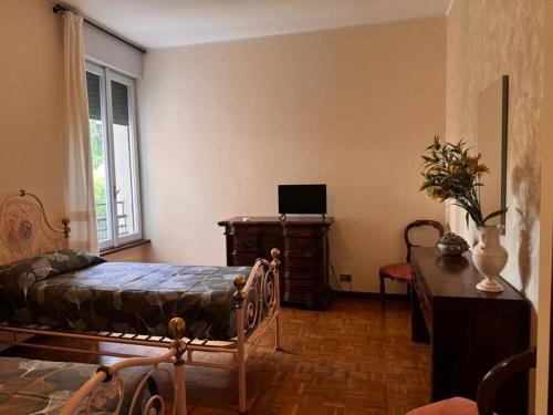 a bedroom with a bed and a desk with a laptop at La casa di Alberto lake view in Laveno