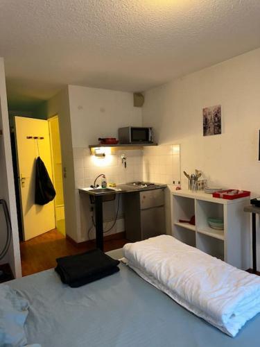 Cette chambre comprend une cuisine avec un lit et un bureau. dans l'établissement Studio N 119 Calme, fonctionnel centre pk gratuit, à Paray-le-Monial