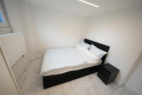 a small bedroom with a bed with white sheets and pillows at Stilvolle 3-Zimmer-Oase in Mühlacker