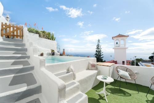 a white villa with a pool and a lighthouse at Casa Hélène in Fasnia