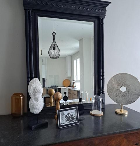 - un miroir sur une table avec quelques articles dans l'établissement L'arrière cour, à Dijon