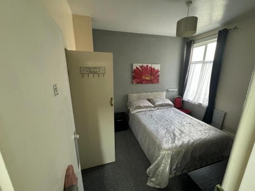 a small bedroom with a bed and a window at Cambria Hotel in Paignton