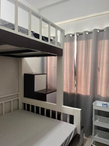 a bedroom with two bunk beds and a window at Chill in Peace Staycation 2BR condo at Field Residences, Sucat near NAIA in Manila