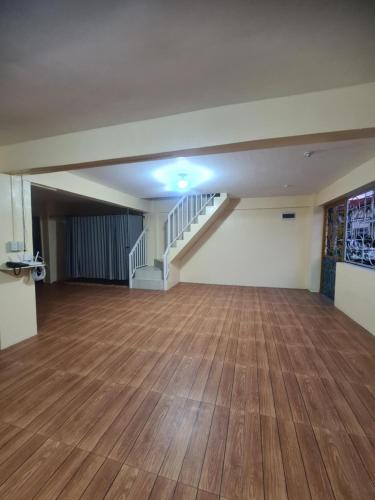 an empty room with a wooden floor and stairs at Js Guest House in Imus