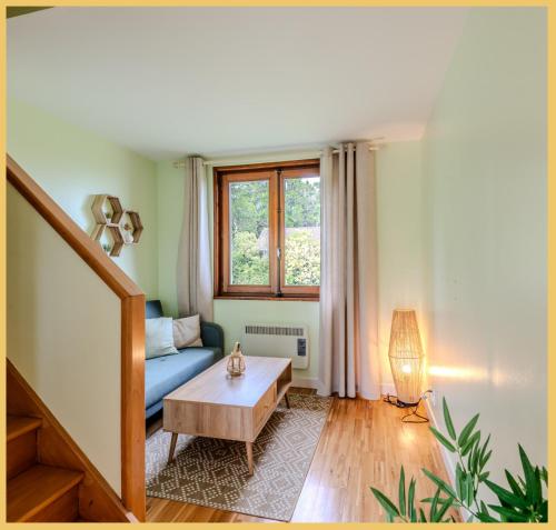 ein Wohnzimmer mit einem blauen Sofa und einem Tisch in der Unterkunft La Maison du Lac I Excenevex in Excenevex