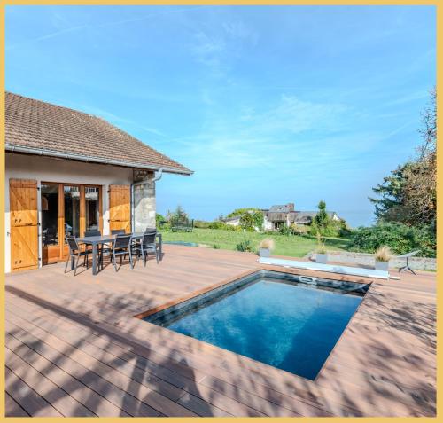 une terrasse avec une piscine, une table et des chaises dans l'établissement La Maison du Lac I Excenevex, à Excenevex