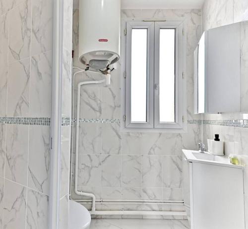 une salle de bain blanche avec une douche et un lavabo dans l'établissement Peaceful Apartment next to Paris Gagny - II, à Gagny