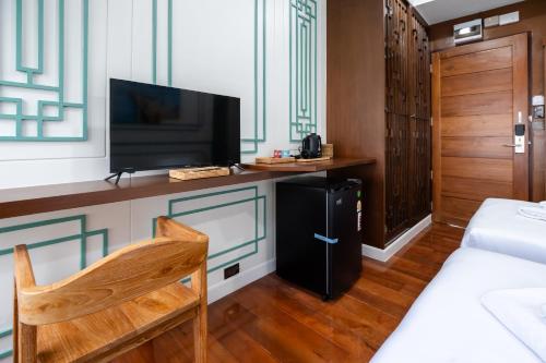 a living room with a tv and a bed and a room with a bed sidx at BB Boutique Sathorn in Bangkok