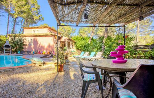 a table with a purple vase on top of it next to a pool at Beautiful Home In Les Arcs With Wifi in Trans-en-Provence