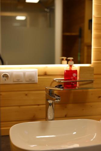 a bathroom sink with a soap dispenser and a mirror at El Bosque by Tiny Away in Vejer de la Frontera