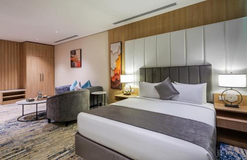 a hotel room with a large bed and a couch at Rhenium Hotel in Riyadh
