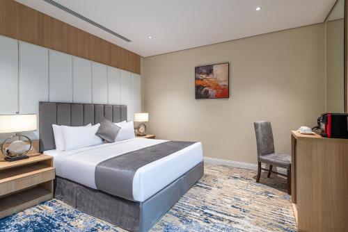 a bedroom with a bed and a desk and a chair at Rhenium Hotel in Riyadh
