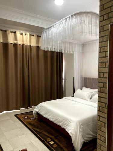 a bedroom with a white bed with a canopy at Afro-American Motel in Kampala