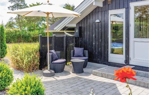 a patio with two chairs and an umbrella at Awesome Home In Slagelse With Wifi in Slagelse
