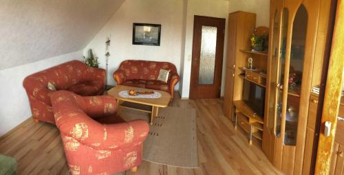Una sala de estar con dos sillas y una mesa. en Ferienwohnung Haus Finkenstein, en Maasholm