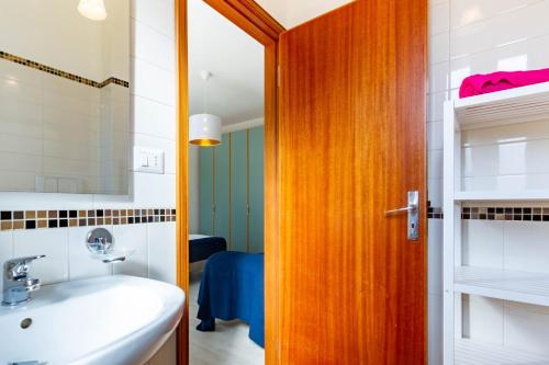 ein Badezimmer mit Waschbecken und Holztür in der Unterkunft Appartamento Bellariva D2 - MyHo Casa in Porto San Giorgio